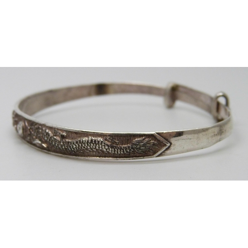 7093 - A white metal dragon design bangle with Oriental marks, 13g, a/f