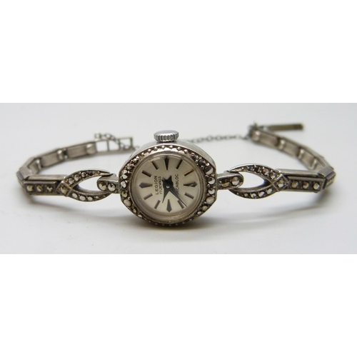 7096 - A silver marcasite set cocktail wristwatch, a pair of white metal earrings with 14k gold ship design... 