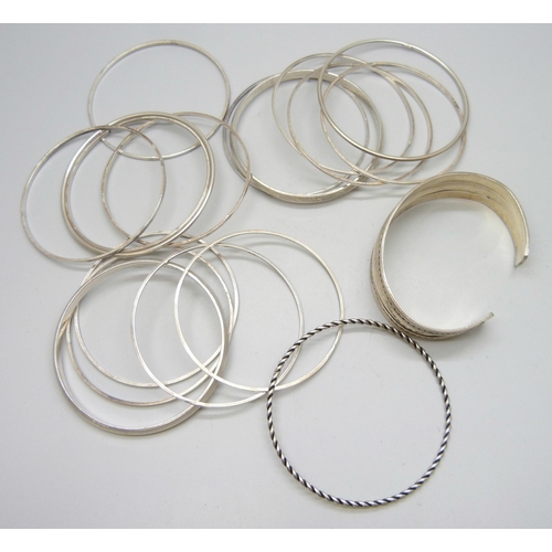 7102 - A white metal cuff bangle, four other white metal bangles, and thirteen stamped silver bangles, 130g... 