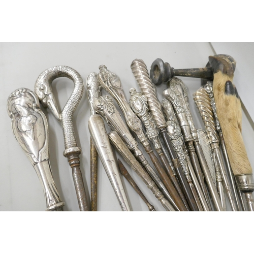 7257 - A large collection of silver topped button hooks including one in the form of a swan's head, a Willi... 