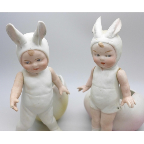 2037 - Gebruder Heubach, Germany, a of pair all bisque Easter bunny boy and girl figures with eggs and arti... 