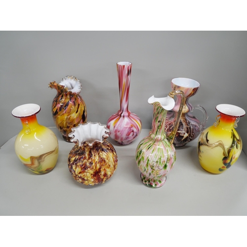 2212 - A collection of seven coloured glass vases most having mottled design with some blown glass examples... 