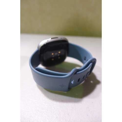 6292 - Fitbit Versa 4 fitness smartwatch with blue infinity band, model no: FB523 *This lot is subject to V... 
