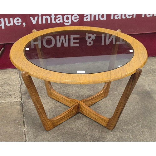 30 - A teak and glass topped circular coffee table