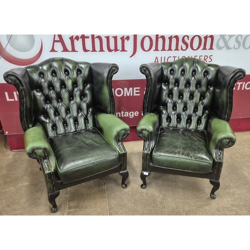 2 - A pair of green leather Chesterfield wingback armchairs