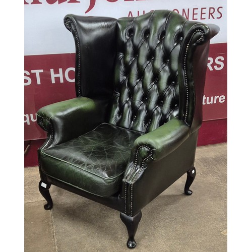 2 - A pair of green leather Chesterfield wingback armchairs