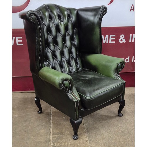 2 - A pair of green leather Chesterfield wingback armchairs