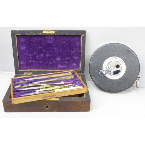 2027 - An early 20th Century mathematical instrument set in wooden box and a large 100ft measuring tape, Th... 