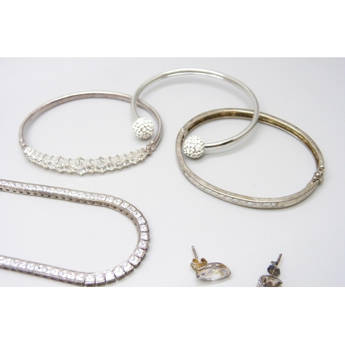 7069 - A collection of silver jewellery including a tennis necklace, another silver stone set necklace, thr... 