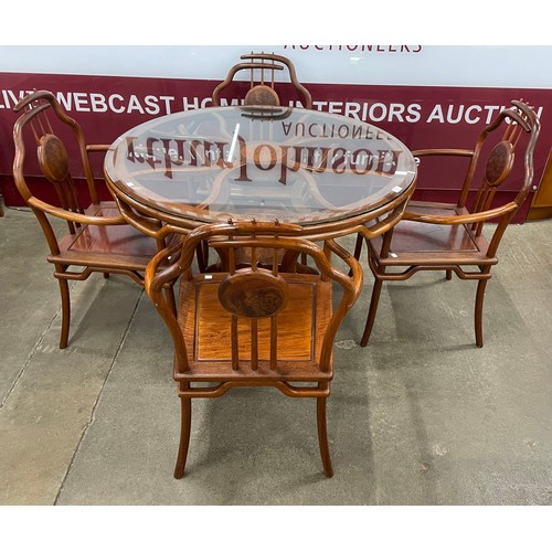 92 - A Chinese hardwood circular glass topped dining table and a set of four chairs