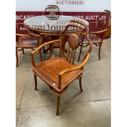 92 - A Chinese hardwood circular glass topped dining table and a set of four chairs