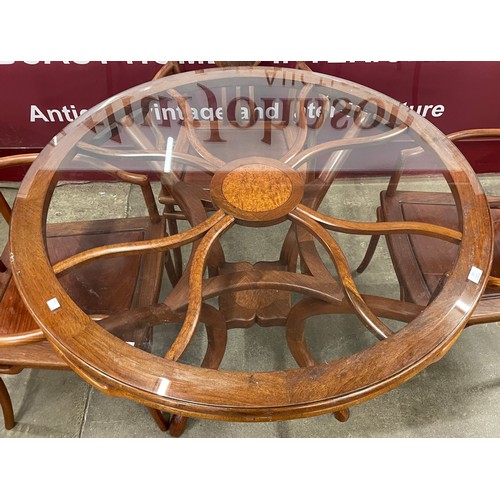 92 - A Chinese hardwood circular glass topped dining table and a set of four chairs