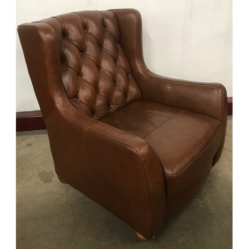 262 - A chestnut brown leather Chesterfield style wingback armchair