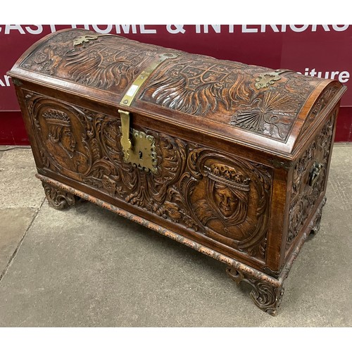 112 - An 19th century extensively carved armorial walnut dome topped trunk