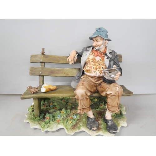 2267 - A porcelain Capodimonte figure of a gentleman sitting on bench