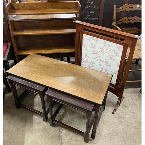 304 - An oak nest of tables, an elm open bookcase and a mahogany firescreen