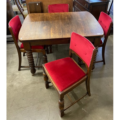 306 - An early 20th Century oak bobbin turned extending dining table and four chairs