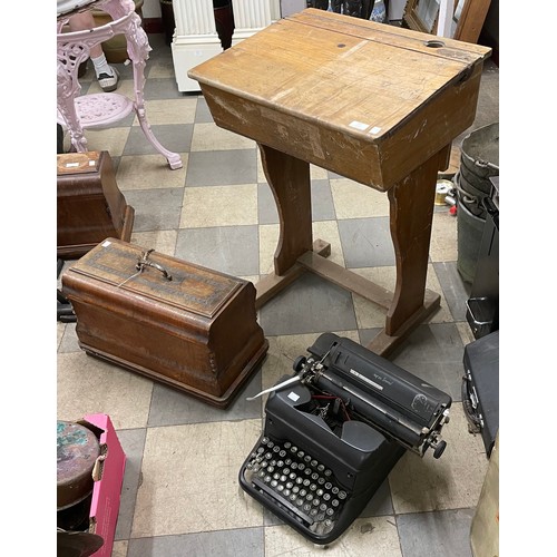 317 - An oak school desk, cased sewing machine and a typewriter