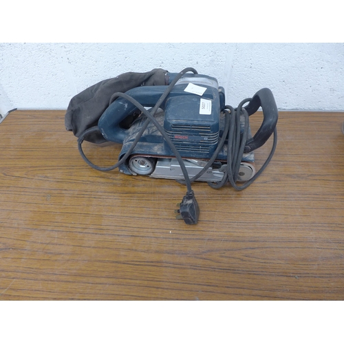 A Bosch GBS 100A belt sander and 2 packs of replacement belts with a ...