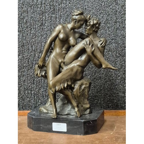 389 - A bronze figure of an erotic female nude and faun, on black marble socle