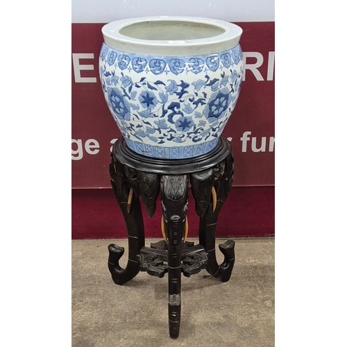 396 - A Chinese blue and white porcelain jardiniere on carved ebonised elephant tripod stand