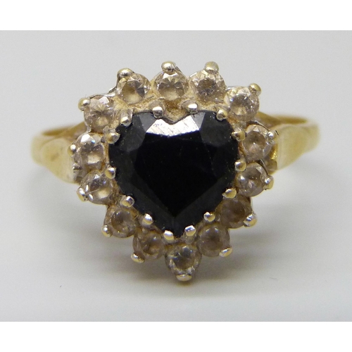 7033 - An 18ct gold heart shaped sapphire cluster ring with white stones, 5.1g, U