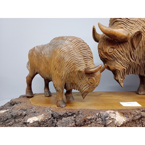 2010 - A large carved wooden figure of two European Bison on trunk base, possibly Polish, base 63cm