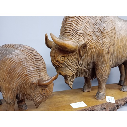 2010 - A large carved wooden figure of two European Bison on trunk base, possibly Polish, base 63cm