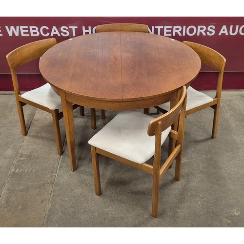 29 - A teak circular extending dining table and four chairs