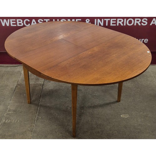 29 - A teak circular extending dining table and four chairs