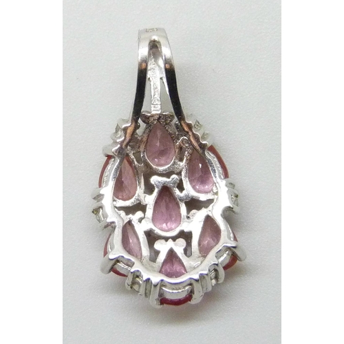 7032 - An 18ct white gold pendant set with pink stones, 4g, 2.5cm