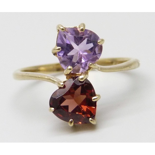 7048 - A 9ct gold crossover ring set with a garnet and an amethyst, 2.3g, P