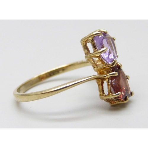 7048 - A 9ct gold crossover ring set with a garnet and an amethyst, 2.3g, P