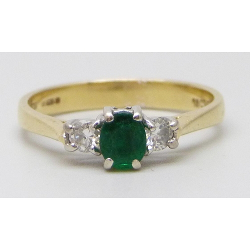 7059 - An 18ct gold, diamond and emerald ring, 2.9g, M