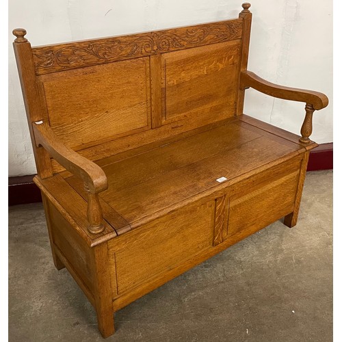 215 - A Cotswold style carved oak settle