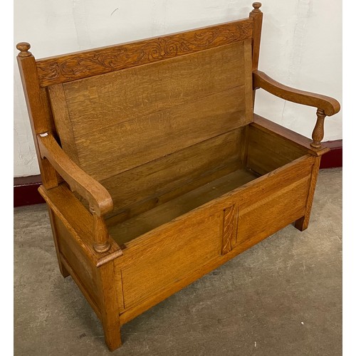 215 - A Cotswold style carved oak settle