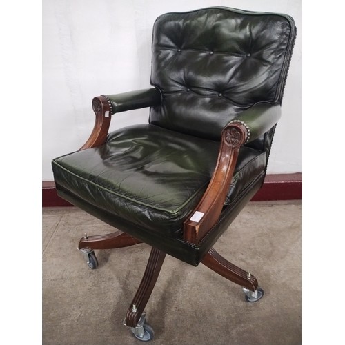 315 - A mahogany and green leather revolving desk chair