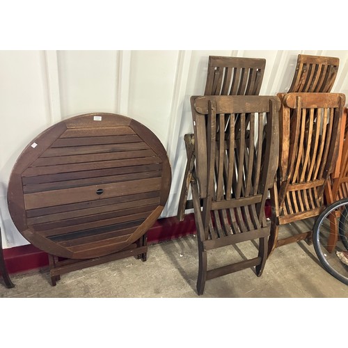 343 - A teak circular folding garden table and four garden steamer chairs