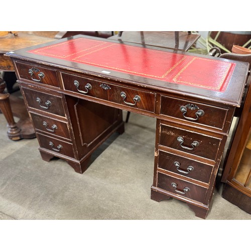 304 - A George III style mahogany and red leather topped pedestal desk