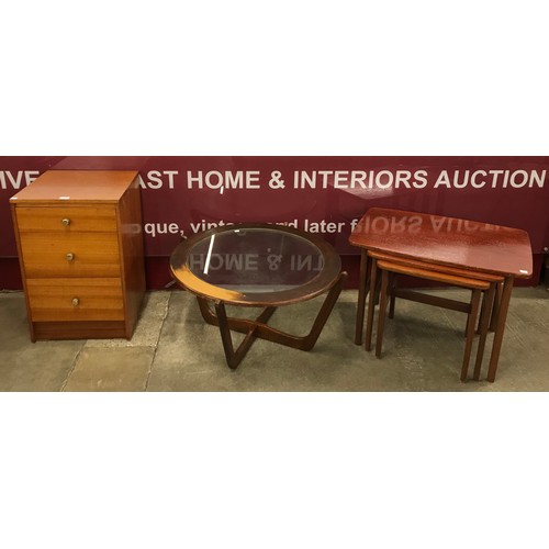 83 - A teak nest of tables, a teak and glass topped circular coffee table and a teak bedside chest