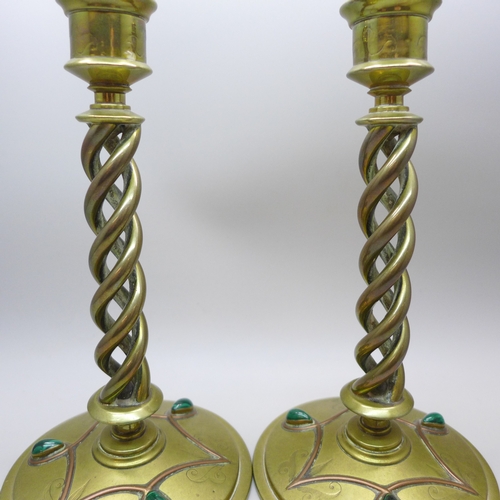 2069 - A pair of Victorian Gothic Revival brass open-twist candlesticks, each set with three cabochon malac... 