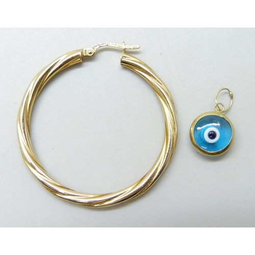 7061 - A 9ct gold hoop earring and a yellow metal framed eye pendant, 2.3g total weight