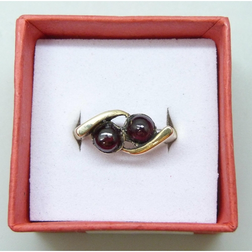 7051 - A 9ct yellow gold ring set with two garnet cabochons, 3.3g, L