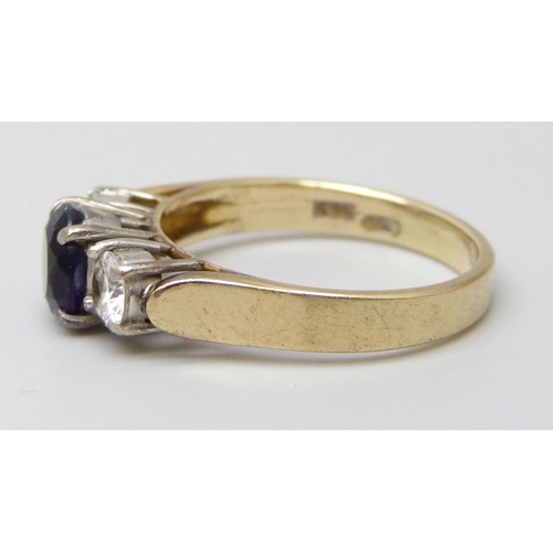 7055 - A 14ct yellow gold trilogy ring set with a purple and clear stones, 3g, L
