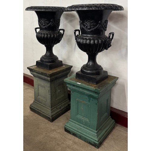 108 - A pair of very large Victorian painted cast iron campana garden urns on stands, 138cms h x 57cms d