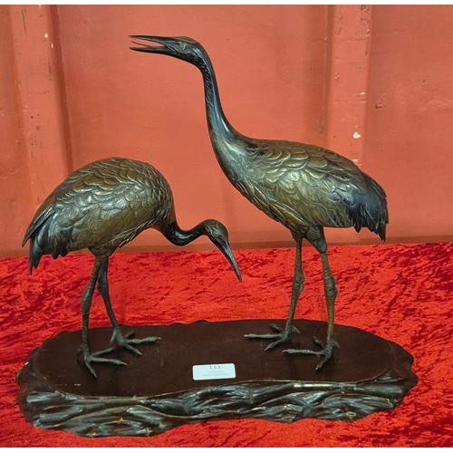 111 - A Japanese Meiji period bronze figure of two cranes, on carved wood stand, 34cms