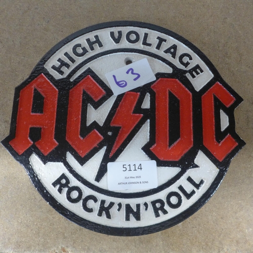 5114 - A cast metal AC/DC wall plaque  *This lot is subject to VAT