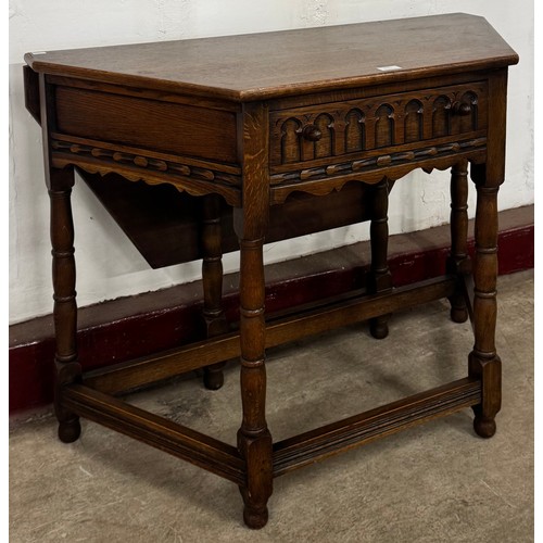 153 - A 17th Century style carved oak drop-leaf credence table