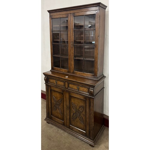 125 - A 17th Century style Maple & Co. carved oak bookcase