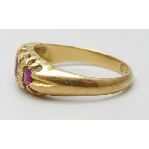 7052 - An 18ct gold three stone ruby and diamond ring, one diamond missing, 2.9g, K
